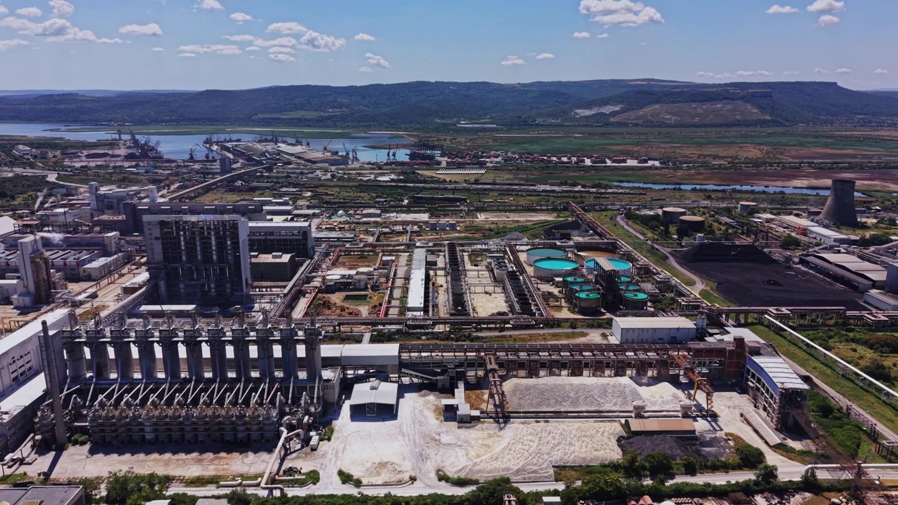 Fábrica y zona industrial cerca del río de día bajo un cielo despejado.