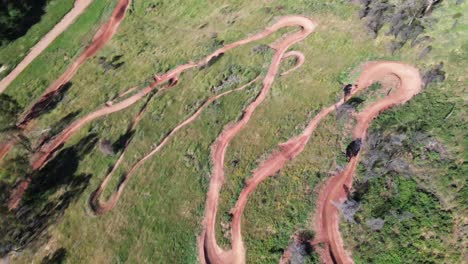 Sendero-Para-Bicicletas-De-Montaña-Con-Ciclista-Bajando,-Tiro-De-Arriba-Hacia-Abajo-Con-Drones