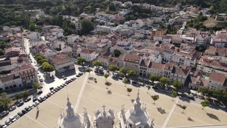 aerial pull out shot overlooking at the cityscape in front of alcobaça monastery, portugal