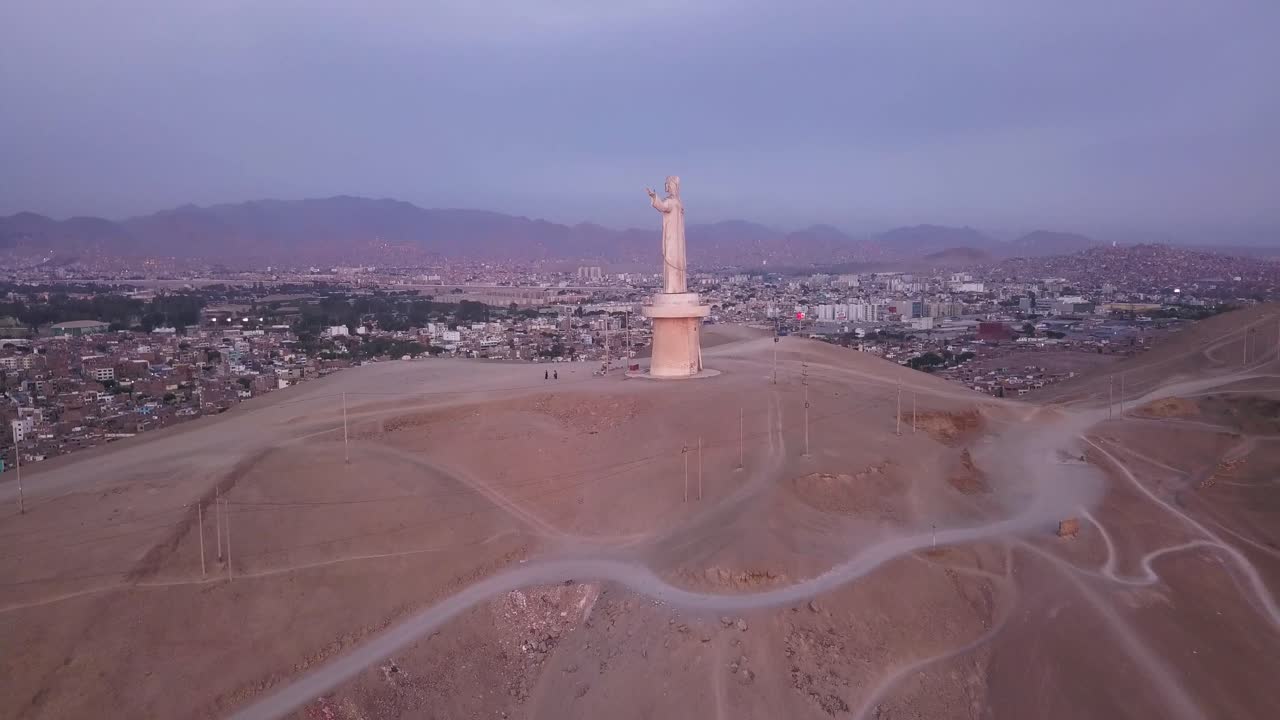 Un'imponente statua di Cristo si erge su una collina, dominando un vasto paesaggio urbano al tramonto. Perfetto per immagini di viaggio, editoriali e culturali