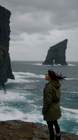 woman admiring dramatic sea cliffs and ocean waves