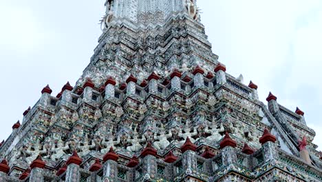 close-up view of wat arun's stupa showcasing detailed ceramic patterns and ornate architectural design.