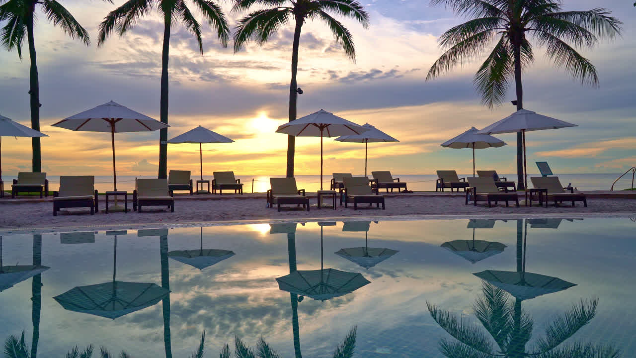 Paraply og stol omkring swimmingpool i resort hotel til fritidsrejser og ferie nær havet strand ved solnedgang eller solopgang tid