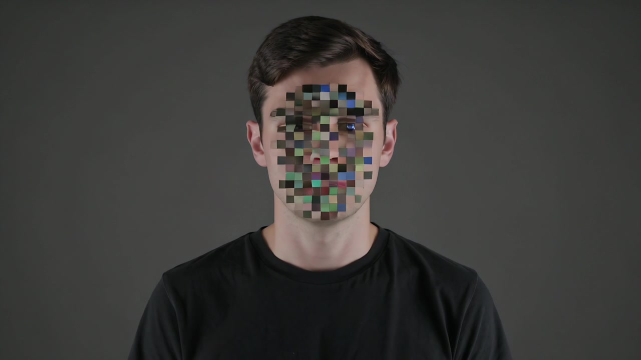Standing adult man in black T-shirt facing camera on gray backdrop, mosaic starting animating face