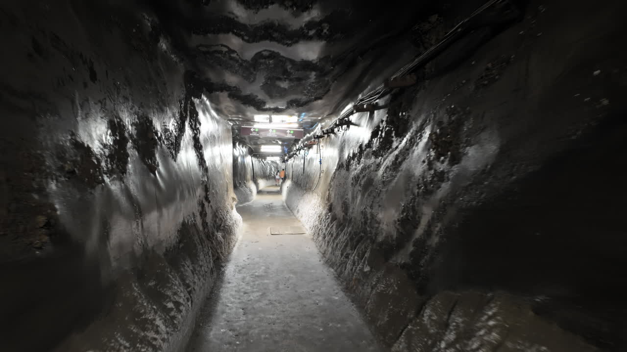 Turda, Romania - July 20, 2025: A narrow, illuminated tunnel inside the Turda Salt Mine