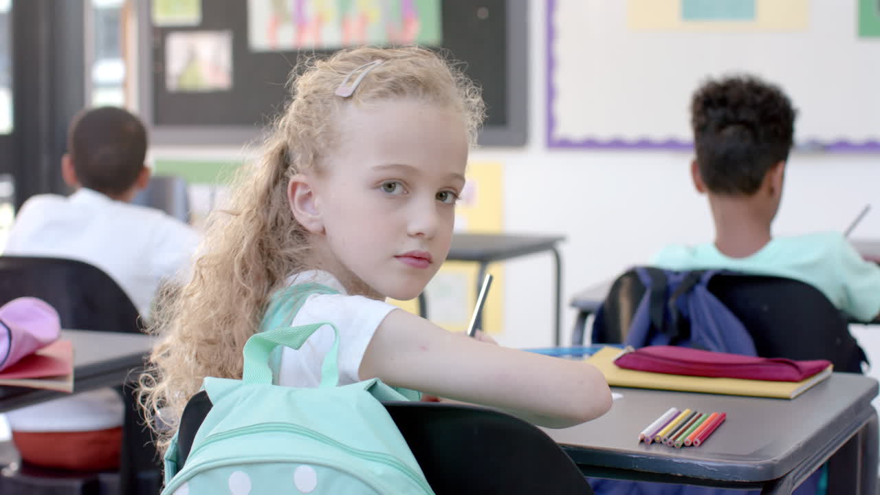 Caucasian girl sits attentively in a classroom at school
