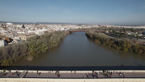 fly over roman bridge of córdoba, guadalquivir river on a sunny day, spain