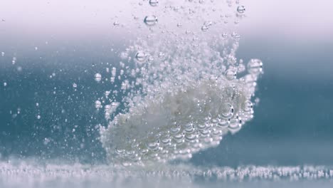 extreme close-up effervescent tablet, pill bubbling underwater. shot on super slow motion camera 1000 fps.