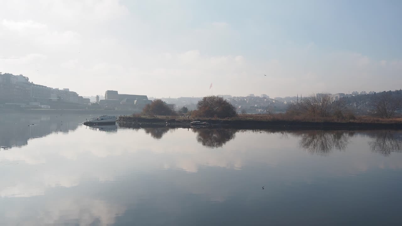 River scene with a foggy cityscape and island