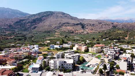 Ciudad-De-Georgioupolis-Y-Montañas-Al-Fondo,-Vista-Aérea-De-Drones