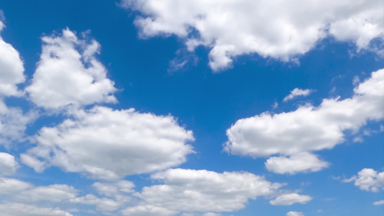 White soft clouds quickly transforming in the sky. Low angle view timelapse on summer daytime.