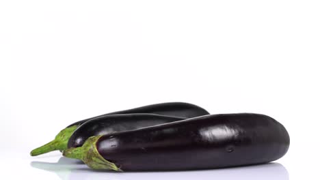 endless loop of a fresh eggplant rotating on a white background. side view.