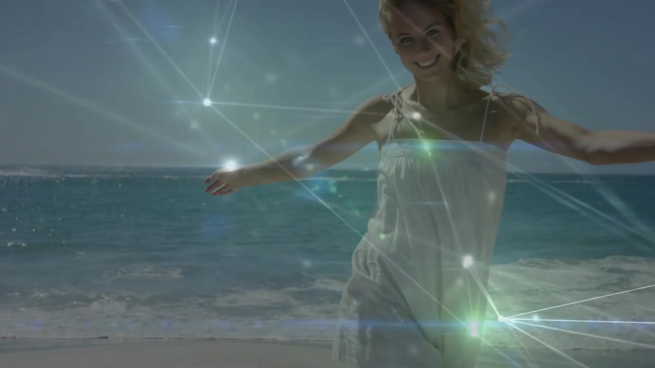 Mujer caminando hacia la cámara en la playa, con superposición tecnológica que se ilumina, se desplaza y se desvanece, dejando la orilla, con un destello de lente.
