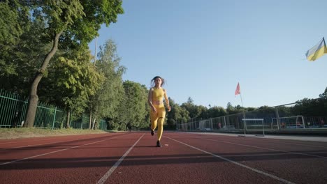 woman running on outdoor track in yellow sportswear