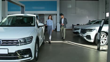 car salesperson discussing a vehicle with a customer at a dealership