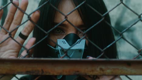 woman behind a fence with a mask