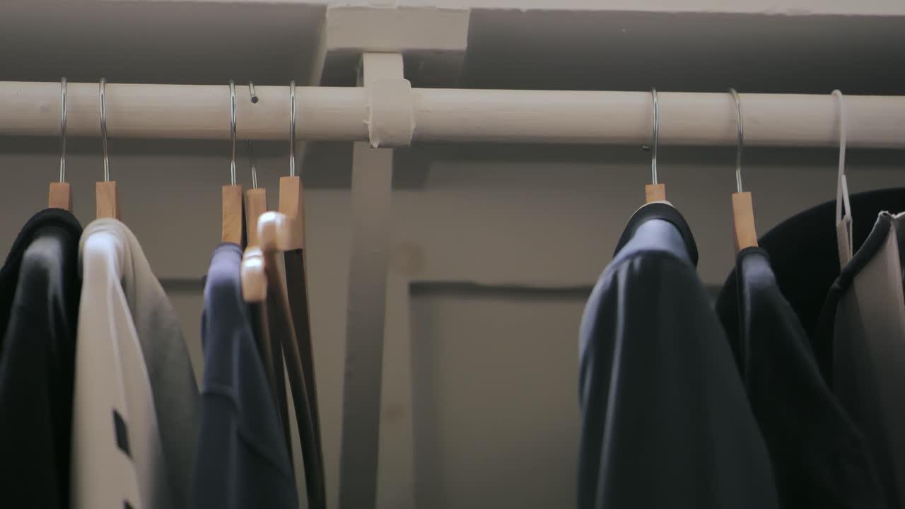 남자는 옷을 찾고 옷장 안에 재을 잡습니다.