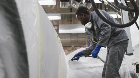 African-American-male-car-mechanic-cleaning-a-car-and-using-a-hose