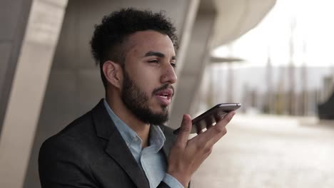 Confident-man-with-bristle-talking-on-smartphone-outdoor