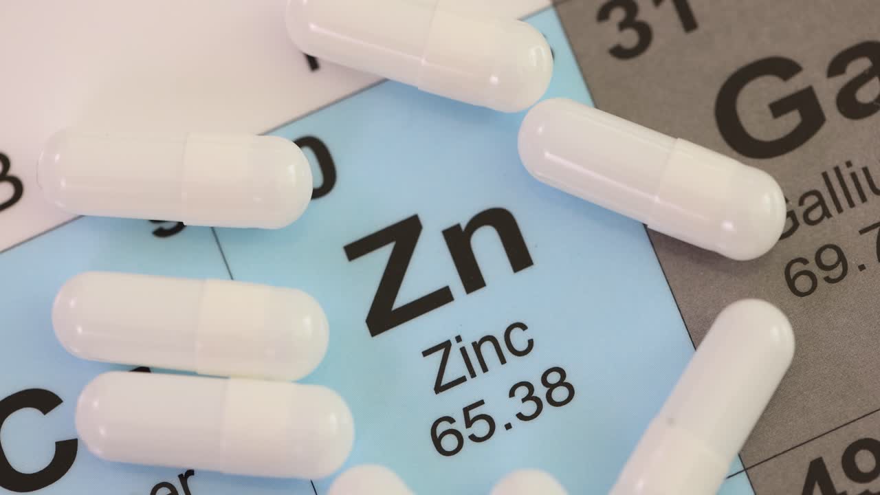 Capsule bianche di microelemento zinco adagiate su cartone con dati.