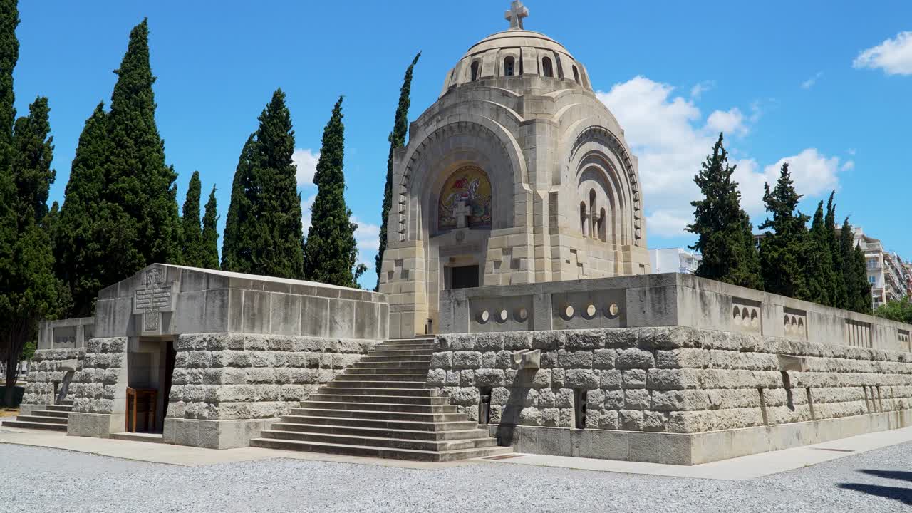 Stone mausoleum at Zeitenlik Serbian military cemetery in Thessaloniki, Greece, surrounded by cypress trees and historic gravestones, honoring fallen Serbian soldiers from World War I
