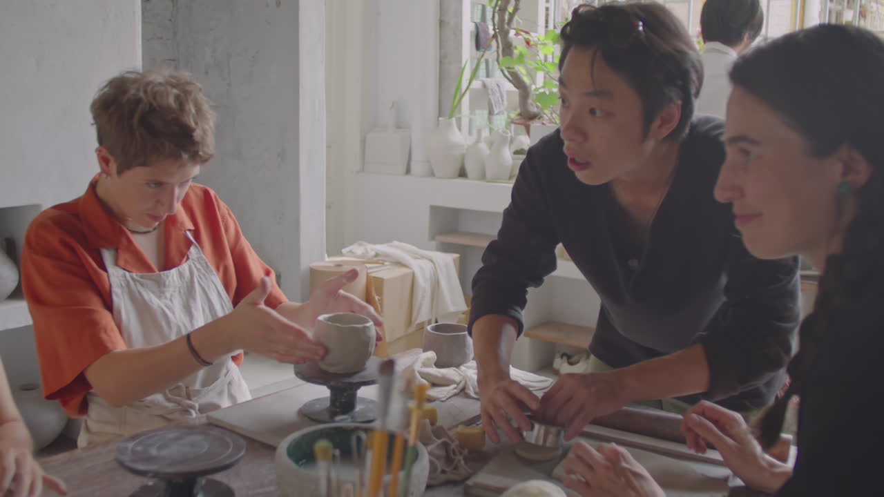 Asian Potter Speaking with Students during Ceramic Art Class