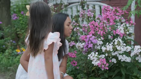 little girl admiring flowers with her mother