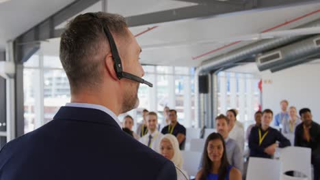 male speaker with headset microphone addressing the audience at a business seminar