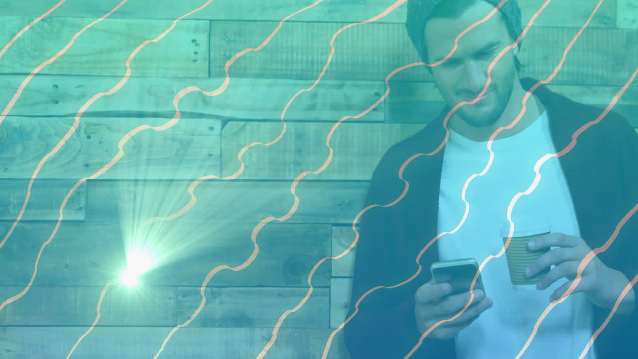 Man scrolling phone and holding coffee by wood wall showing marketing charts over turquoise lines