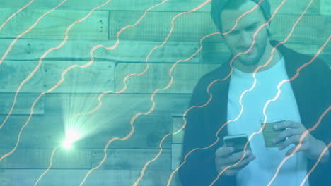 man scrolling phone and holding coffee by wood wall showing marketing charts over turquoise lines