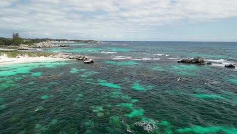 Vista-Aérea-De-La-Isla-Rottnest,-Costas-Arenosas-Suavemente-Acariciadas-Por-Las-Aguas-Cristalinas-Del-Océano-Índico,-La-Bahía-De-Largo-Alcance-Ofrece-Un-Remanso-De-Belleza-Natural-Y-Tranquilidad.