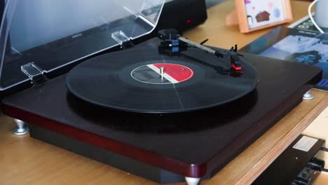Putting a record on a vinyl record player and closing the top cover