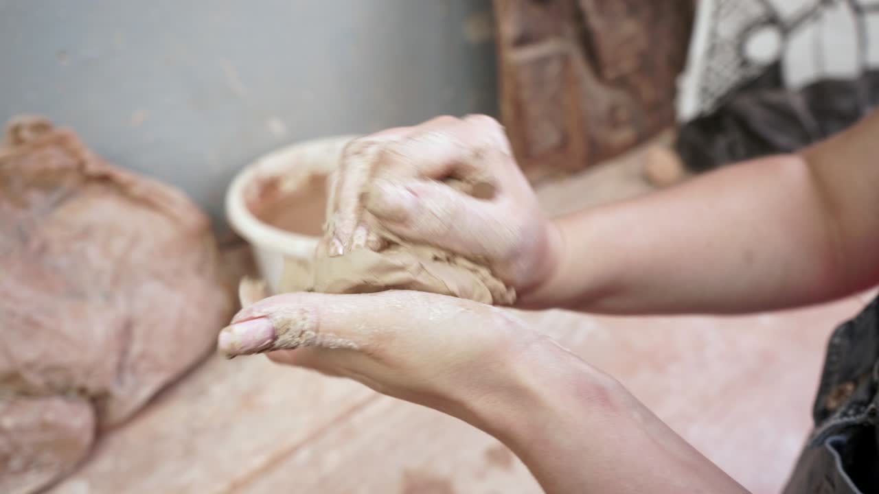 una joven hace una jarra de arcilla. las manos de las mujeres moldean la cerámica.