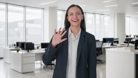 happy indian business woman waving hi to the camera