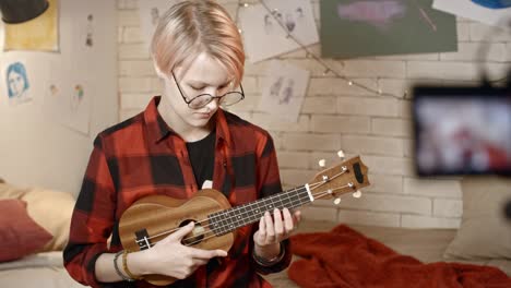 teenage girl playing ukulele on camera