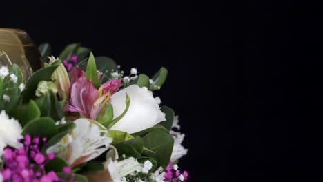 Golden-white-and-purple-flower-arrangement-spinning-black-background-detail-shot-slider-and-spinning