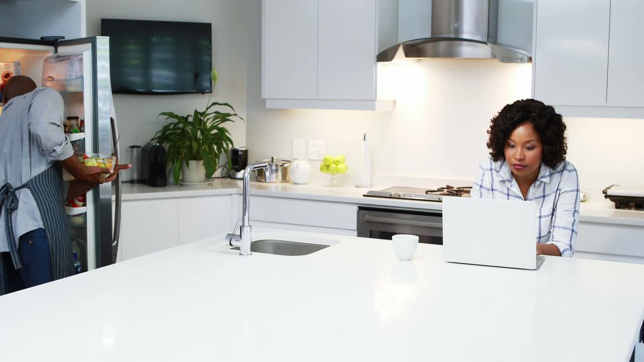 Coppia che usa il laptop in cucina 4k