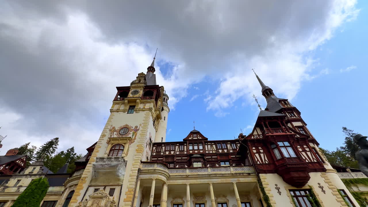 Sinaia, Romania, 17 July 2025: Neo-Renaissance facade of Peles Castle in Romania. Detailed facade of Peles Castle in Sinaia, Romania with its decorated walls and tall spires under dramatic clouds
