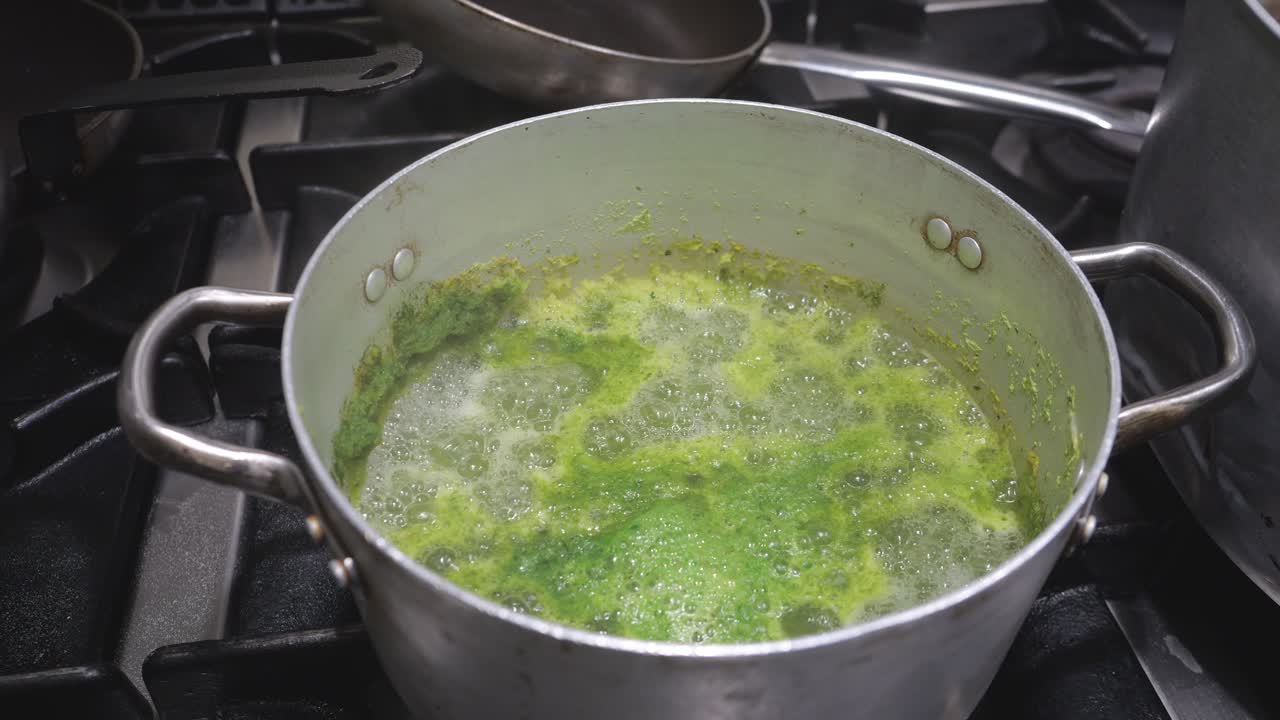 Cooking process for a traditional green sauce, documenting the piquant blend of ingredients as they thicken under high heat