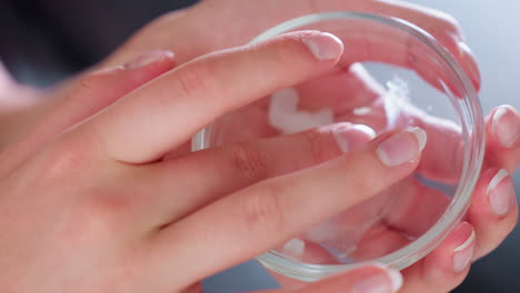 close hand view of lady mixing cream together, preparing to apply, beauty routine, skincare treatment, facial care, moisturizing, self-care, soft skin, hydration, skincare products