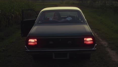 woman in vintage car at sunset