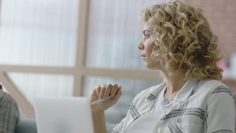 Hermosa-Joven-Mujer-De-Negocios-De-Raza-Mixta-Usando-Una-Computadora-Portátil-Digital-En-Una-Reunión-De-Oficina-Trabajando-En-Un-Proyecto-De-Investigación-De-Intercambio-De-Ideas-En-Línea-En-Una-PC-Móvil-Compartiendo-Ideas