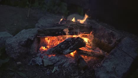 close-up of campfire and stone fireplace, dolly shot, evening colors