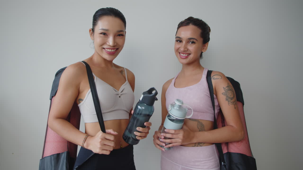 Two Asian Sportswomen Posing for Camera on White Background
