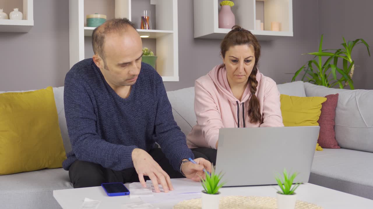 pareja preocupada calculando facturas de alto precio y deudas bancarias.