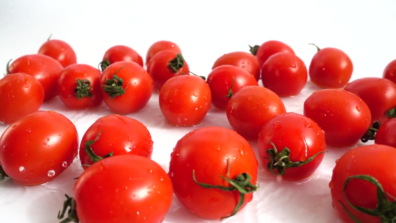 La caída de tomates cherry en el agua. Cámara lenta
