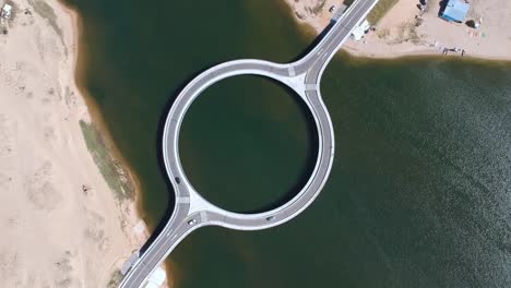 drone footage view of a round bridge in the ocean in uruguay