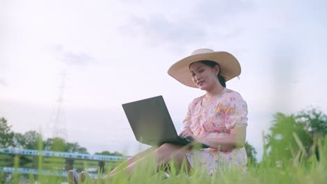 외부 자연 공간에서 노트북을 사용하는 젊은 아시아 여성