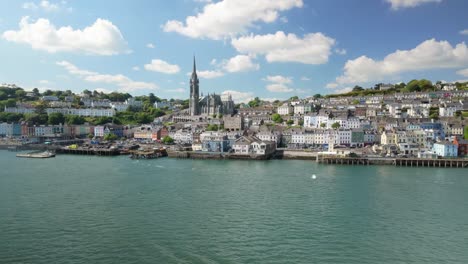 view from a moving ferry or cruise ship as it passes the picturesque town of cobh, ireland. rotating around church tower