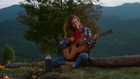 musical traveler eseguire una canzone suonare la chitarra acustica in montagna natura.